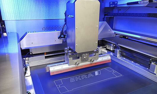 Interior view of a screen printing machine. Squeegee on a surface.