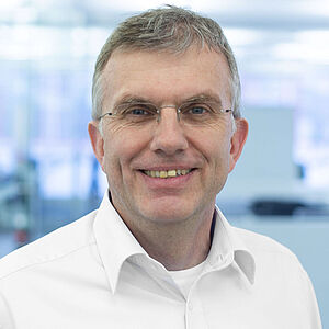 Smiling man in a white shirt.