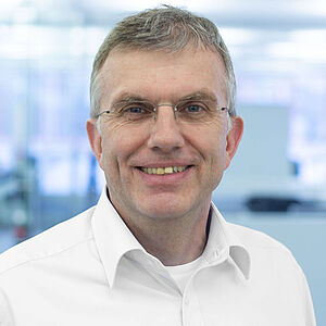 Lächelnder Mann in weißem Hemd.