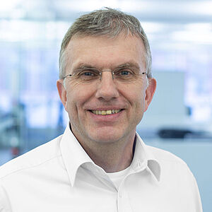 Lächelnder Mann in weißem Hemd.