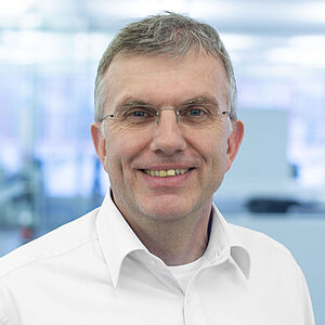 Smiling man in a white shirt.