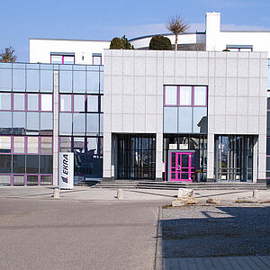 Exterior view of a building with a modern glass facade that emphasizes the architecture and entrance area.