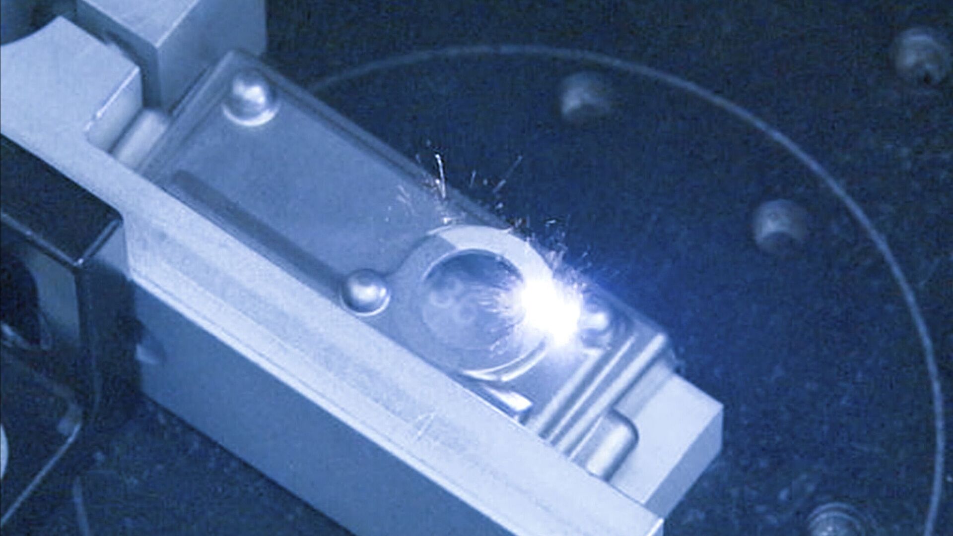 Interior view of a laser machine, laser beam hitting a silver object.