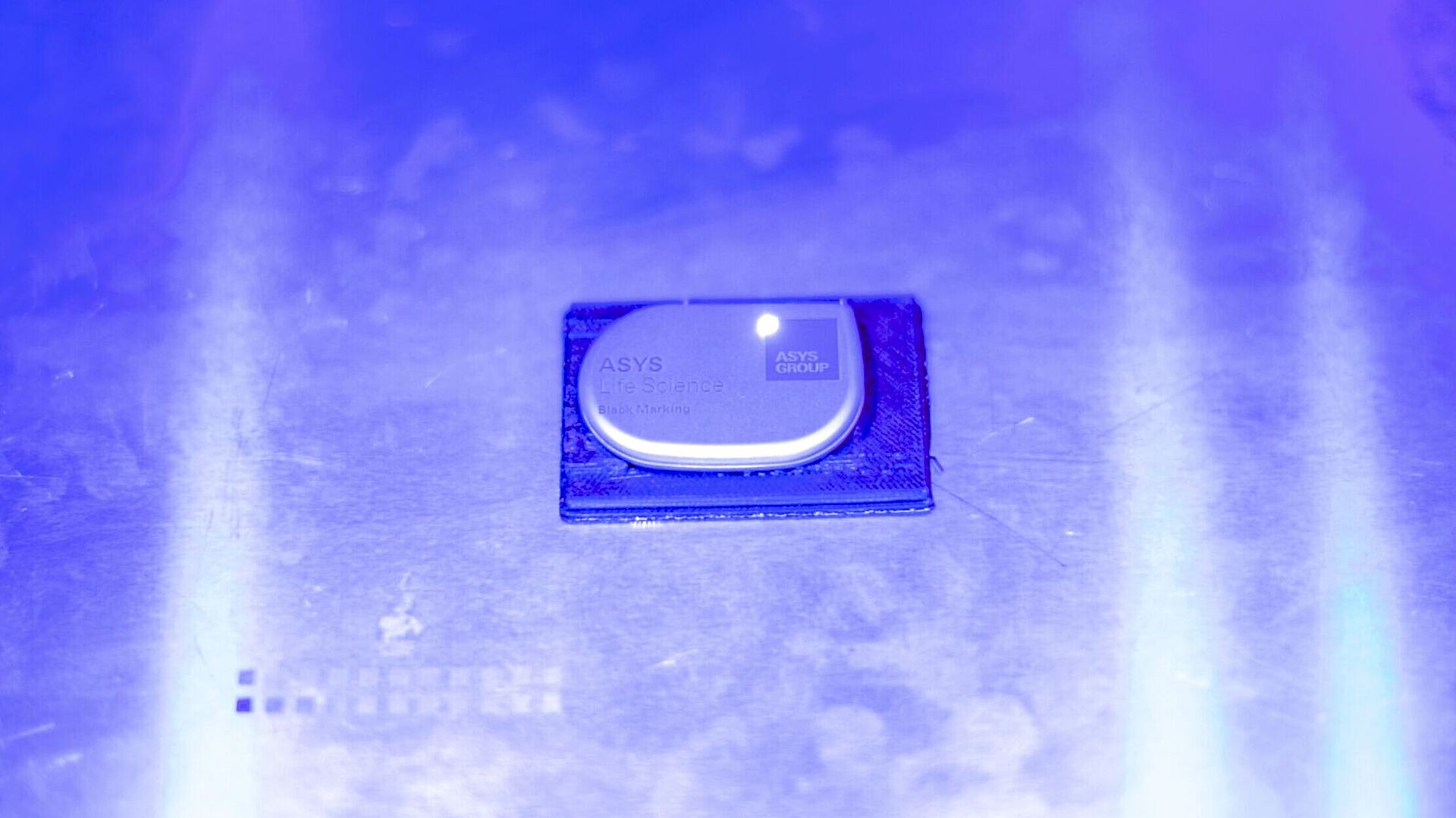 Markierchip auf einem silbernen Untergrund im blauen Licht.