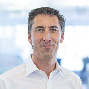 Smiling man in a white shirt.