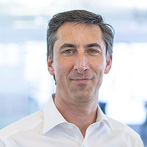Smiling man in a white shirt.