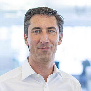Smiling man in a white shirt.