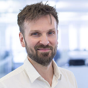 Smiling man in a white shirt.