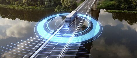 A truck drives across a bridge spanning a river. In the background, a dense forest stretches out. Blue, futuristic glowing lights circle around the truck.