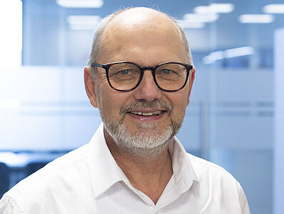Smiling man in a white shirt.