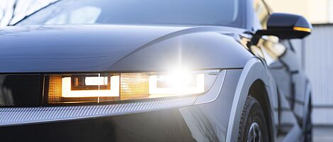 Left front of a modern car with focus on the headlight, featuring a distinctive, technical design.