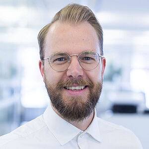 Smiling man in a white shirt.