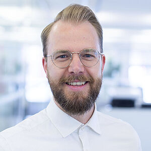 Smiling man in a white shirt.