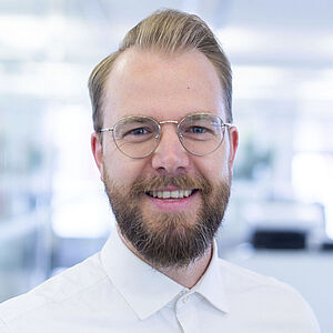 Smiling man in a white shirt.