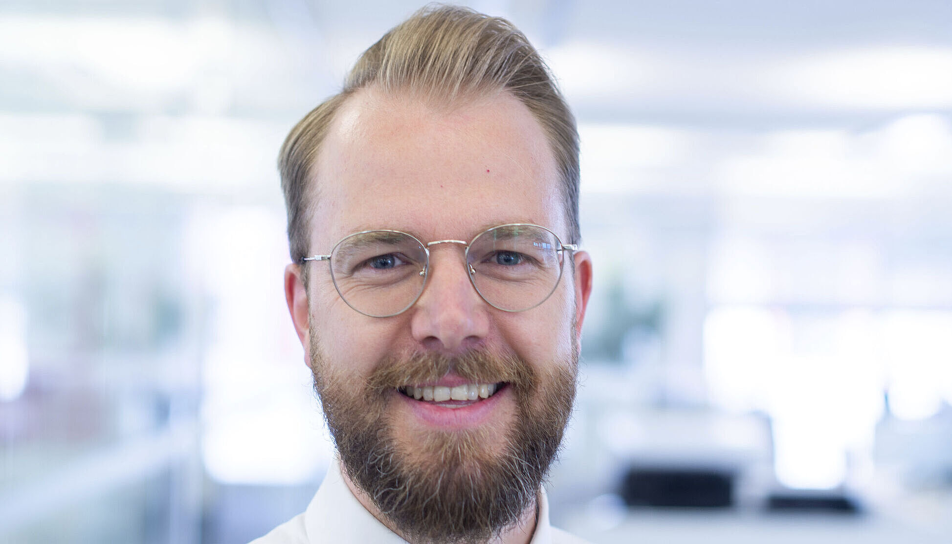 Smiling man in a white shirt.