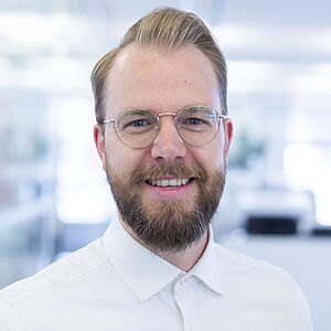 Smiling man in a white shirt.