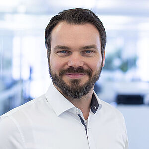 Smiling man in a white shirt.