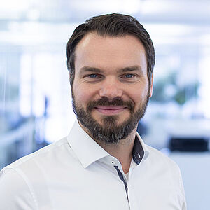 Smiling man in a white shirt.