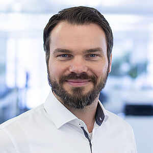 Smiling man in a white shirt.