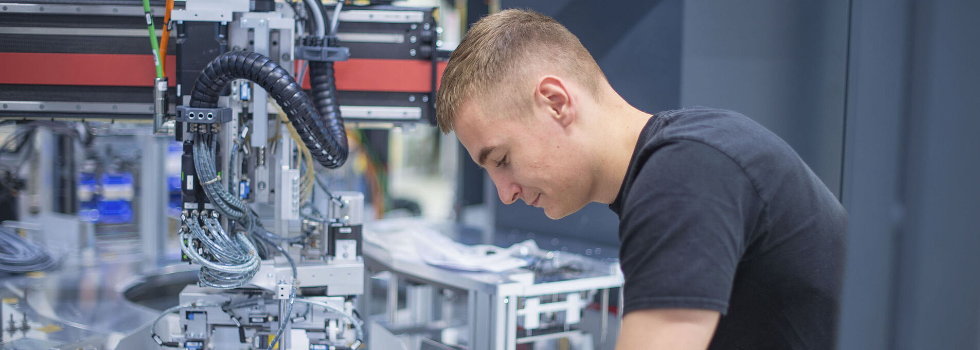A young man is working intently on a machine.