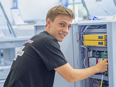 Young man working on a machine in a production environment.
