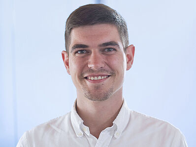 Smiling man in a white shirt.