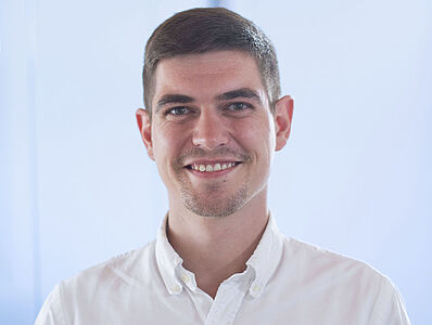 Smiling man in a white shirt.