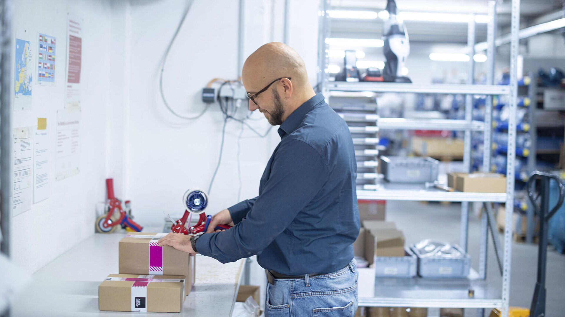 Mann verpackt einen Karton im Warenausgang