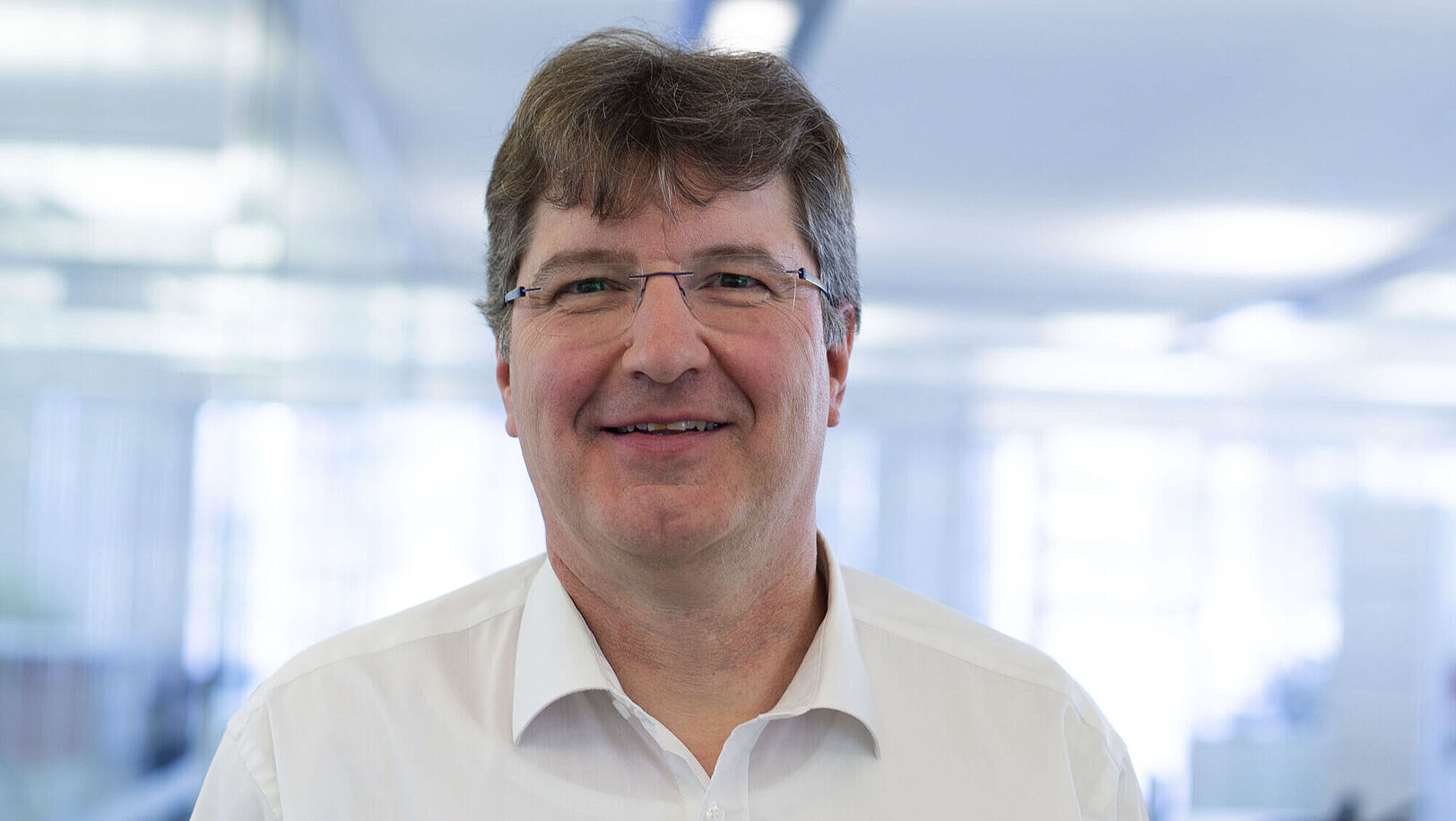 Smiling man in a white shirt.
