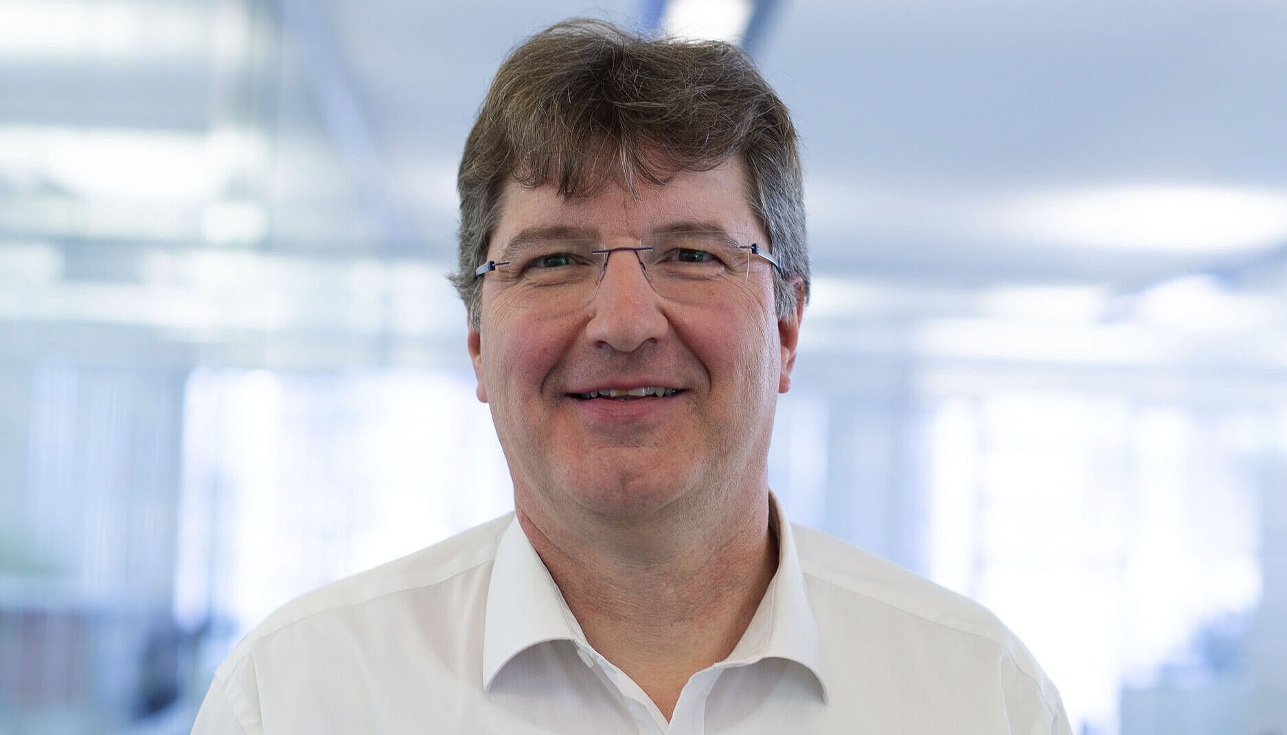 Smiling man in a white shirt.