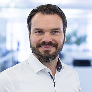 Smiling man in a white shirt.