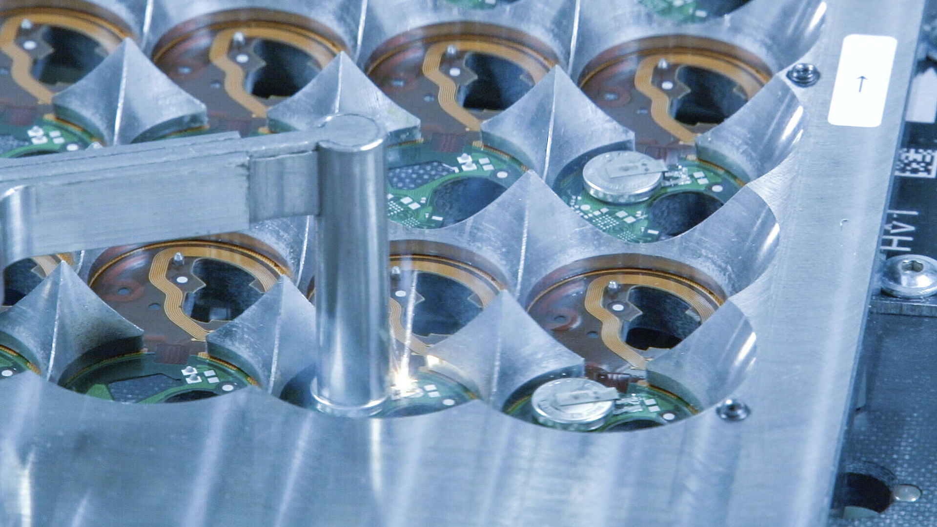 Metal stencil presses onto a circuit board, a laser is visible at one spot.