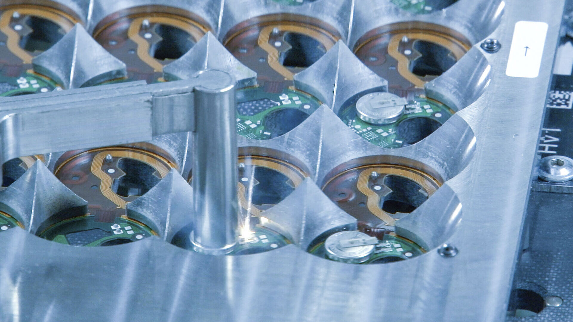 Metallschablone presst auf eine Leiterplatte, an einer Stelle ist ein Laser erkennbar.