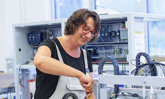 Eine Frau arbeitet an einer Maschine.