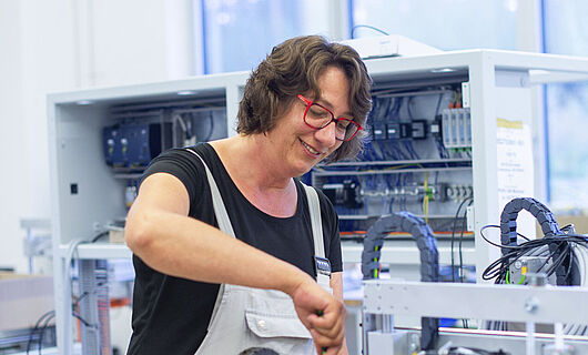 A woman is working on a machine.