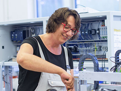 Eine Frau arbeitet an einer Maschine.