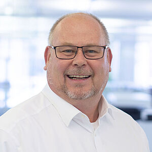 Smiling man in a white shirt.