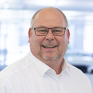Smiling man in a white shirt.