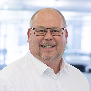 Smiling man in a white shirt.