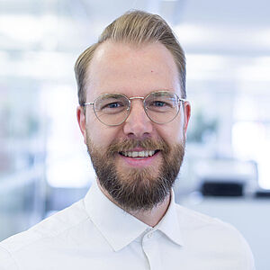 Smiling man in a white shirt.
