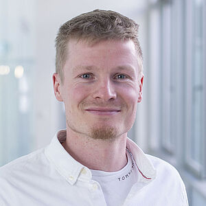 Smiling man in a white shirt.