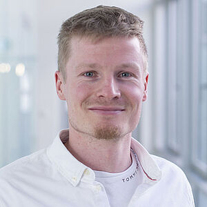 Lächelnder Mann in weißem Hemd.