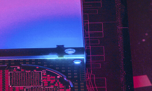 Interior view of a laser machine with blue, violet and reddish light.