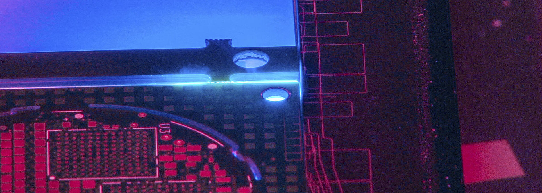 Interior view of a laser machine with blue, violet and reddish light.
