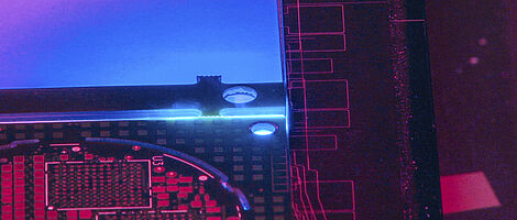 Interior view of a laser machine with blue, violet and reddish light.