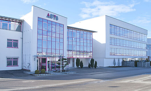 Gesamtansicht eines modernen Firmengebäudes der ASYS Group mit Glasfront.
