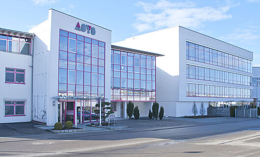 Wide view of a modern ASYS Group company building with a glass façade.