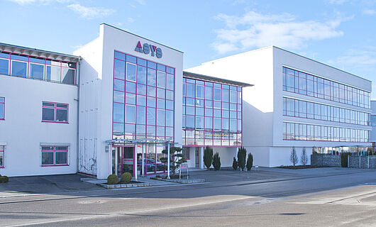Gesamtansicht eines modernen Firmengebäudes der ASYS Group mit Glasfront.