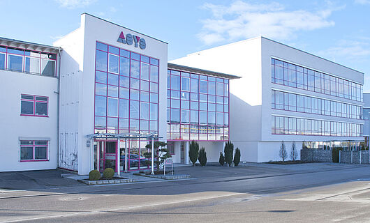 Wide view of a modern ASYS Group company building with a glass façade.