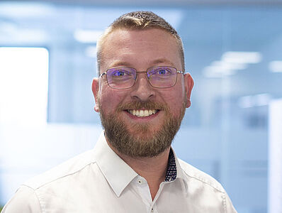 Smiling man in a white shirt.